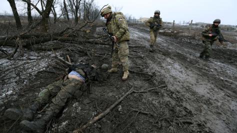 Тело на обочине Сергей Лойко / Los Angeles Times Украинские солдаты проходят мимо тела пророссийского сепаратиста неподалеку от аэропорта.